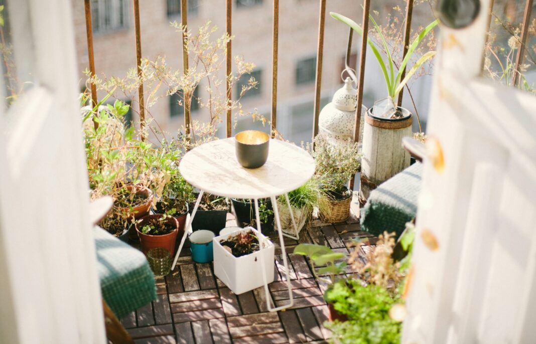 Small balcony garden with potted plants and a bistro table